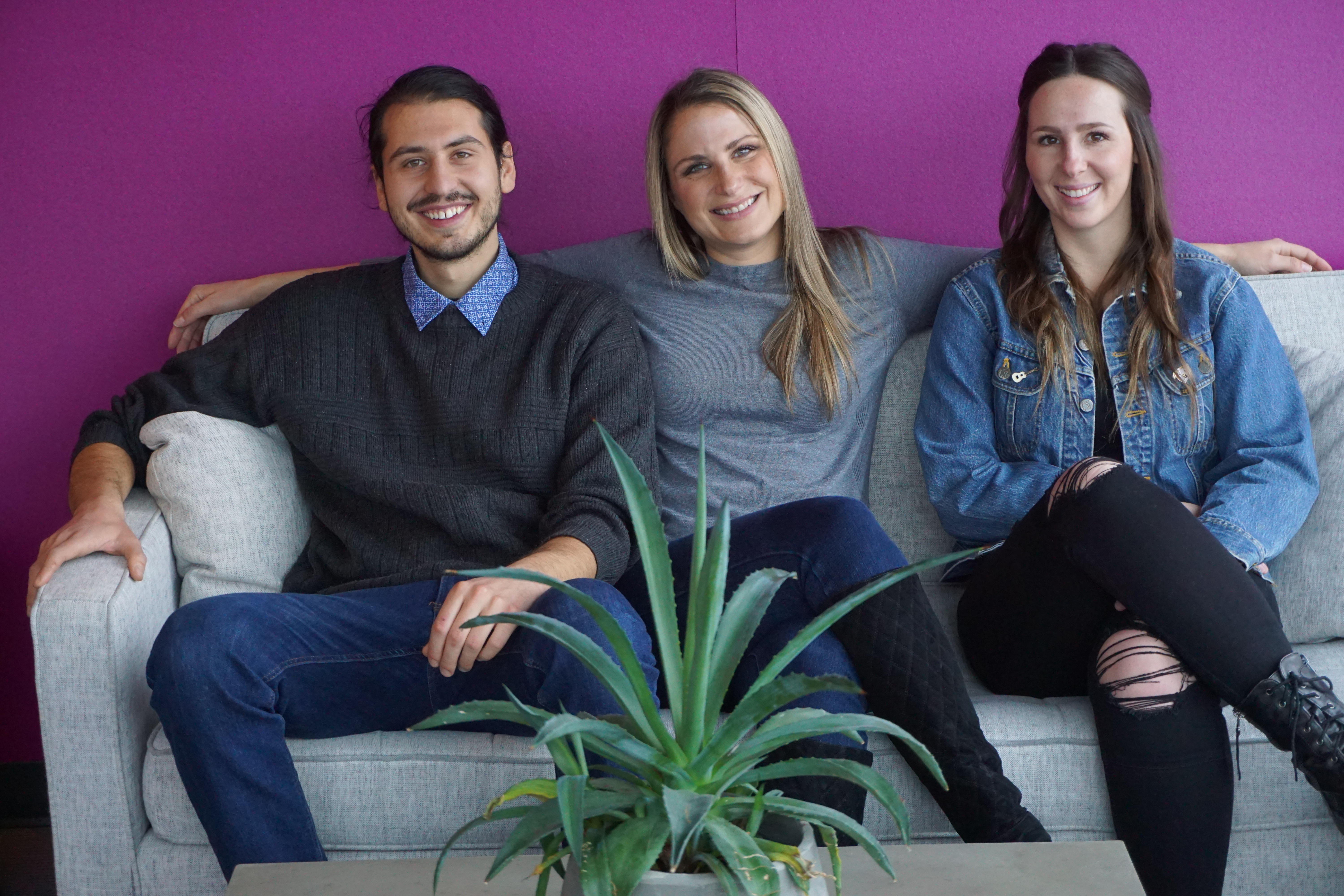Sage Recruiting team members sitting together on a couch in the office